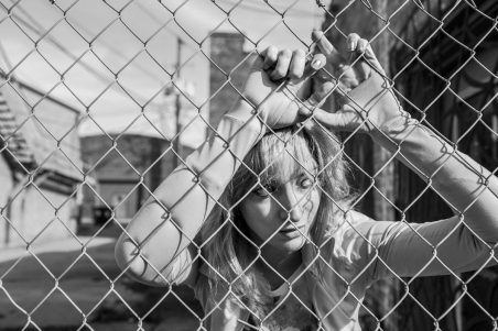 gratisography leaning against fence giving up